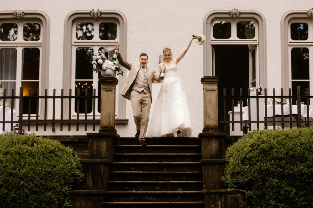 Hochzeitsfotograf Bielefeld Braut und bräutigam verlassen die Hochzeitslokation sehr glücklich
